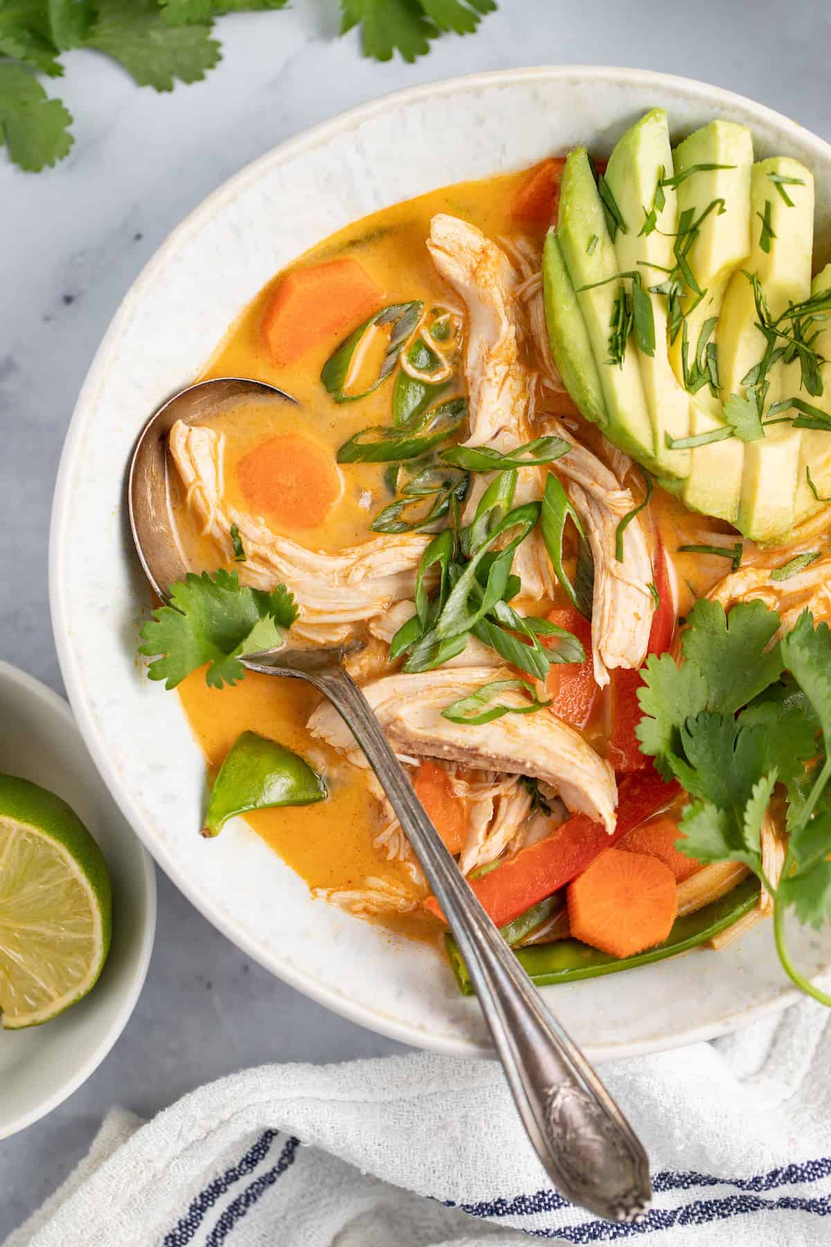 thai chicken noodle soup with avocado and fresh herbs