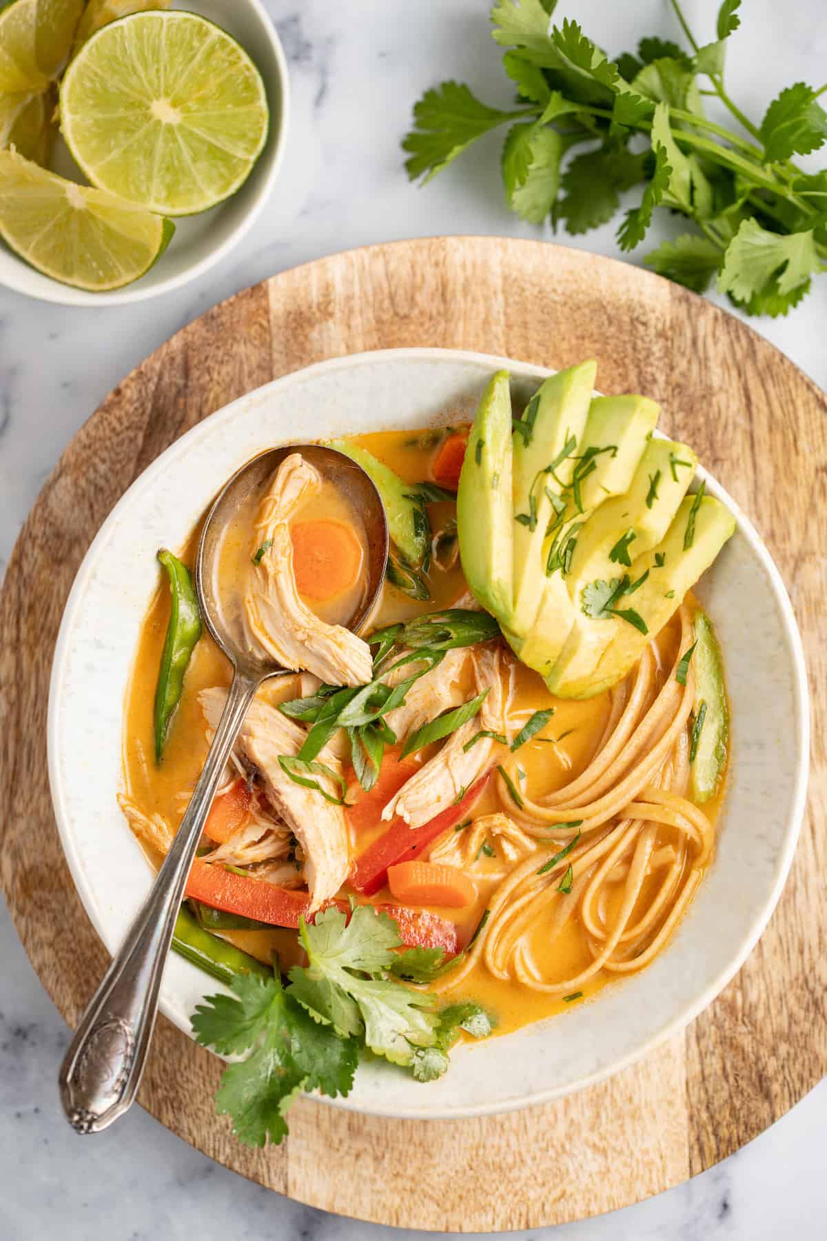 thai chicken noodle soup with avocado and fresh herbs