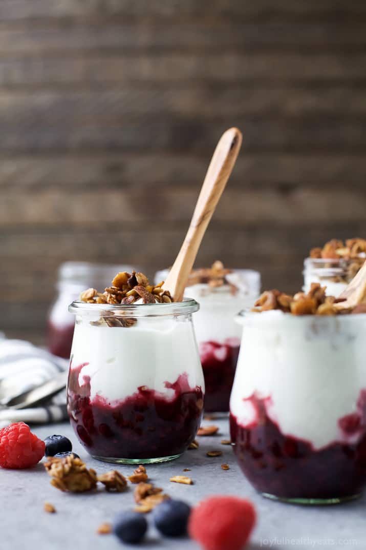 Jars of Fresh Yogurt Parfait with a Mixed Berry Compote and crunchy vanilla almond granola