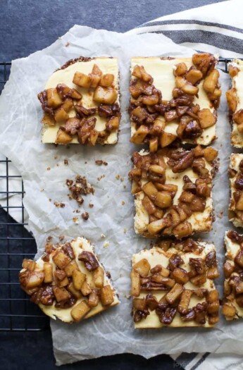 Parchment paper with pieces of Apple Crisp Cheesecake Bars.