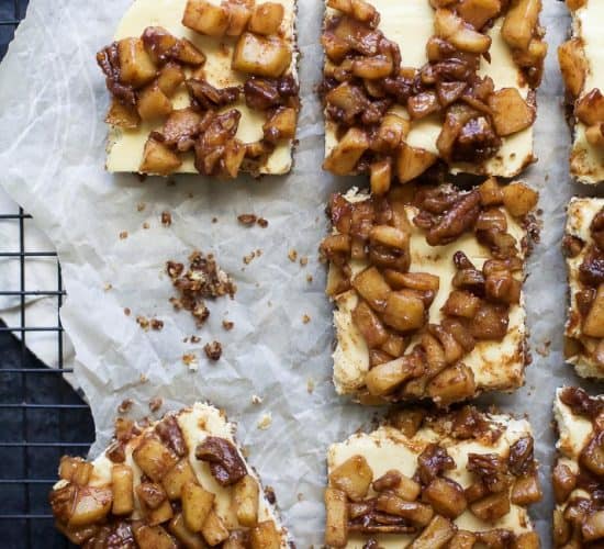 Parchment paper with pieces of Apple Crisp Cheesecake Bars.