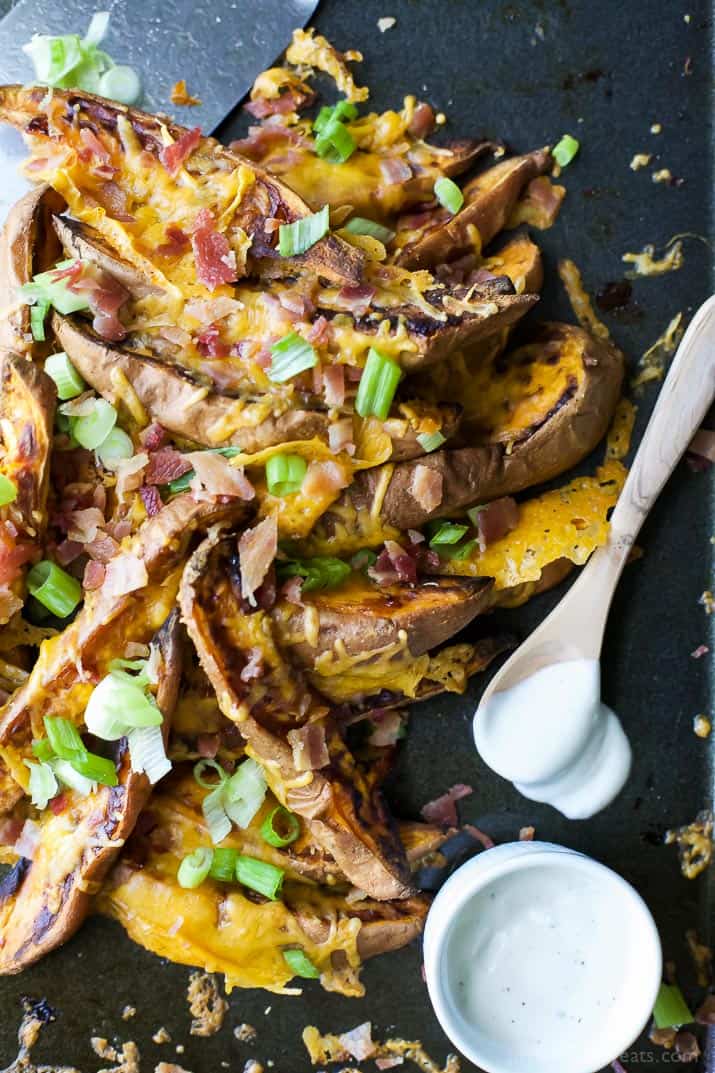 Loaded Sweet Potato Wedges on a tray with creamy dipping sauce