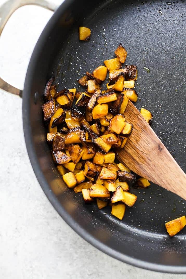 Diced butternut squash browning in a skillet