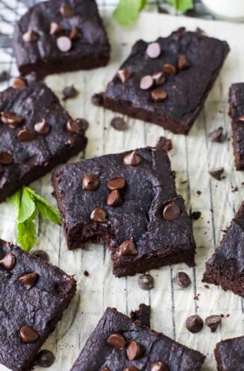 Dairy Free Pumpkin Brownies Arranged on a Parchment-Covered Cooling Rack with Fresh Mint Leaves