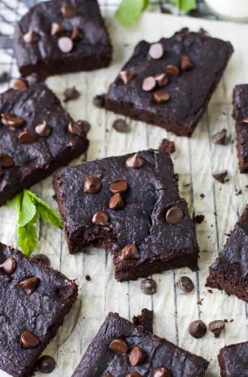 Dairy Free Pumpkin Brownies Arranged on a Parchment-Covered Cooling Rack with Fresh Mint Leaves