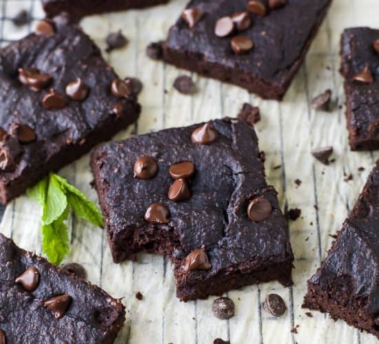 Dairy Free Pumpkin Brownies Arranged on a Parchment-Covered Cooling Rack with Fresh Mint Leaves