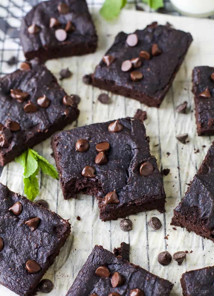 Dairy Free Pumpkin Brownies Arranged on a Parchment-Covered Cooling Rack with Fresh Mint Leaves