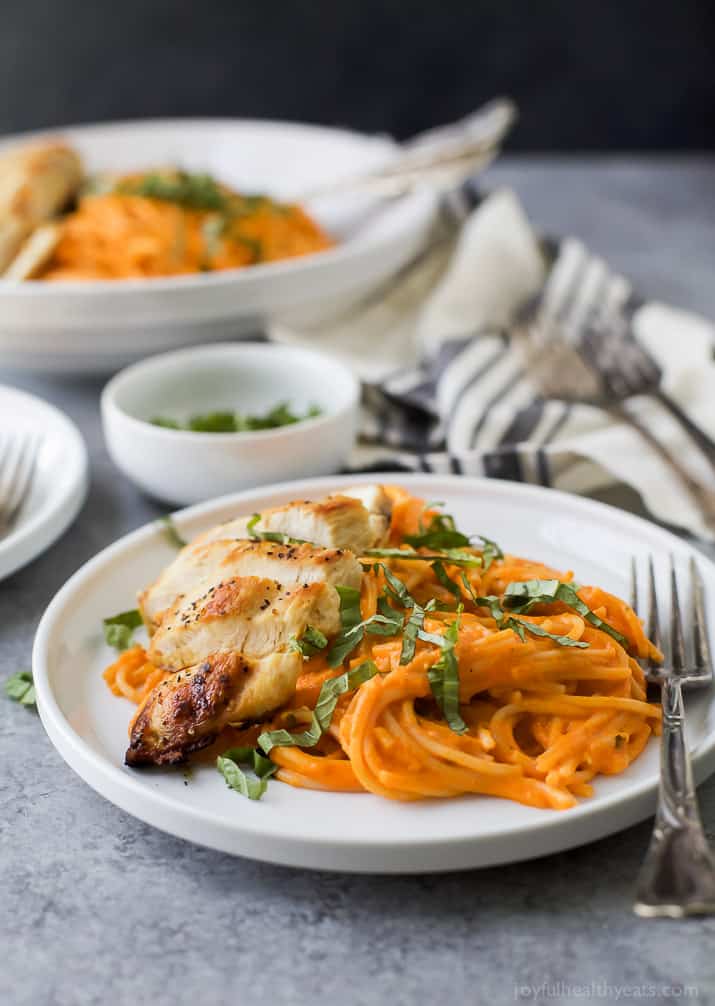 Gluten Free Pasta served with pan seared Chicken and a Creamy Roasted Red Pepper Sauce on a plate