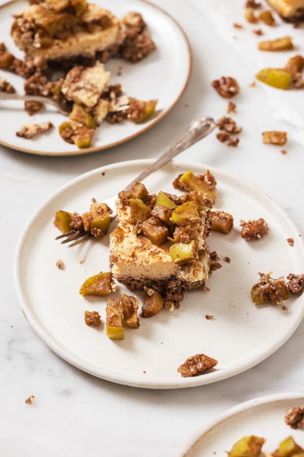 One slice of apple cheesecake bars on a plate.