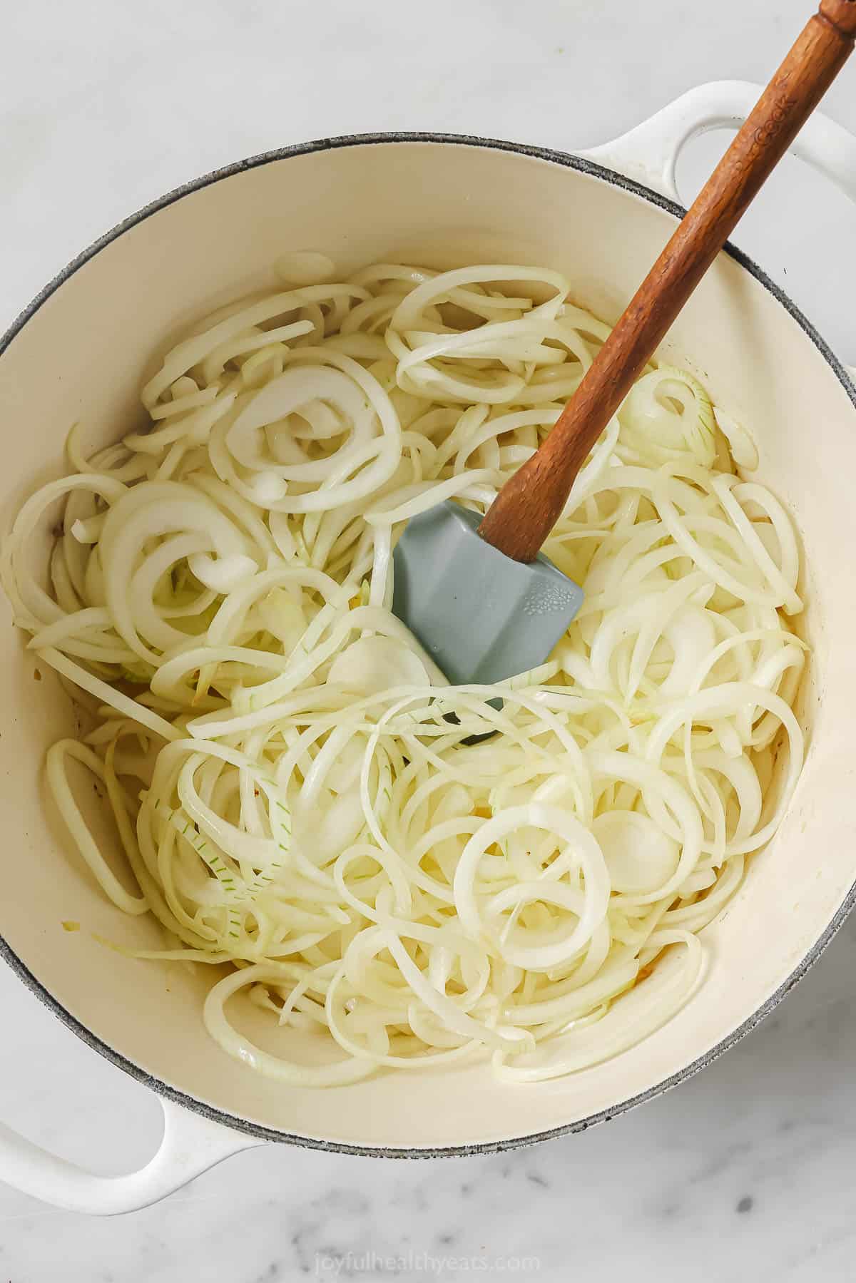 Adding the onions to the pot. 