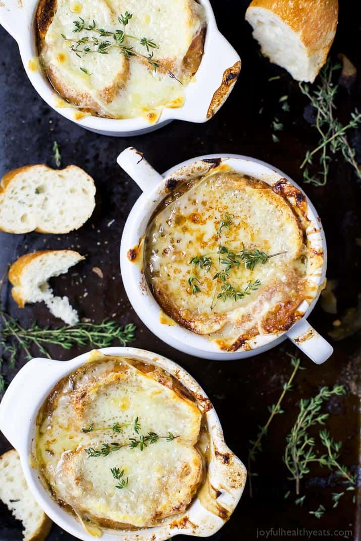 Three white bowls filled with French Onion Soup