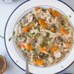 chicken and rice soup in a white bowl with a spoon