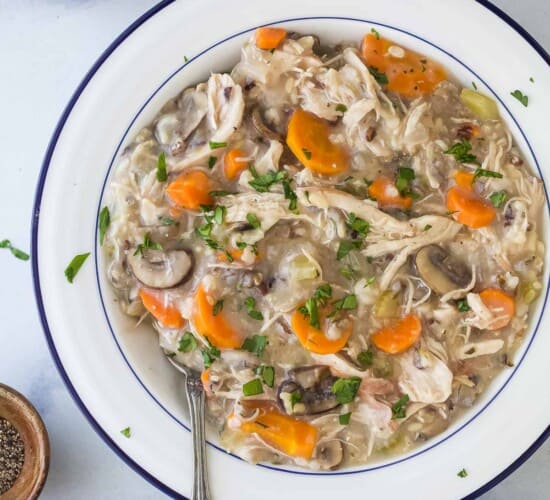 chicken and rice soup in a white bowl with a spoon