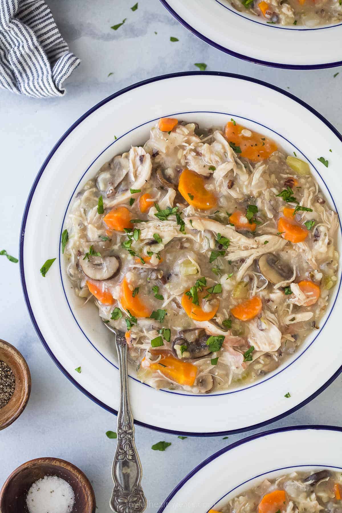 chicken and rice soup in a white bowl with a spoon