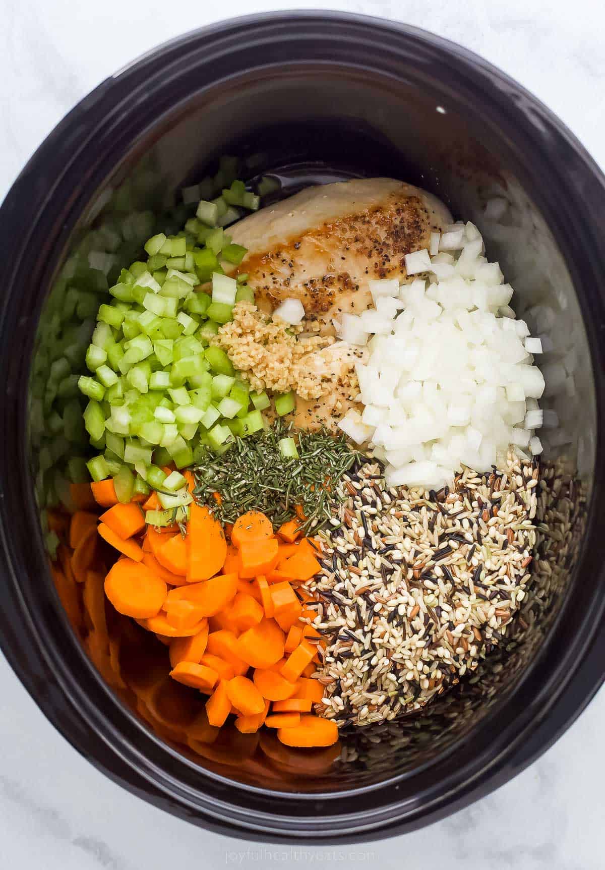 This creamy Crockpot Chicken and Wild Rice Soup is filled with wild rice, tender chicken, and veggies. Only 5 minutes of prep time! vegetables, wild rice, and chicken in a crockpot