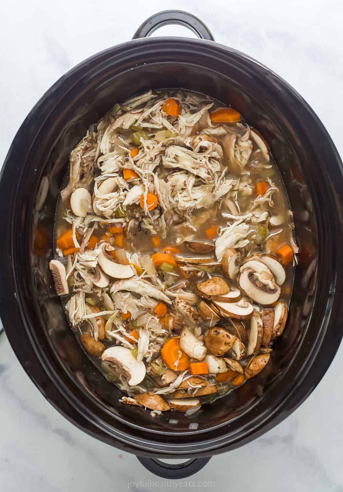 mushrooms and other vegetables in a soup in the crockpot