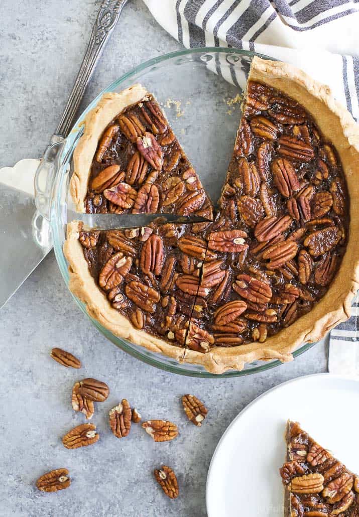 A Pecan Pie in a pie dish with a slice taken out.