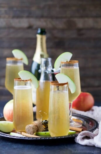 Easy 2 ingredient Apple Cider Mimosas - you'll love this fall twist on a classic mimosa. These Apple Cider Mimosas are the perfect bubbly cocktail to start off your holidays!