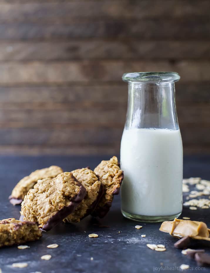 Chocolate-dipped Oatmeal Peanut Butter Cookies leaning on a glass of milk