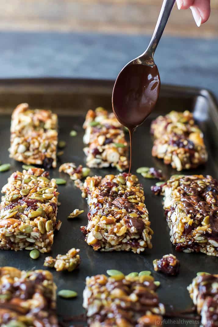 Homemade Cranberry Almond Granola Bars being Drizzled with Chocolate