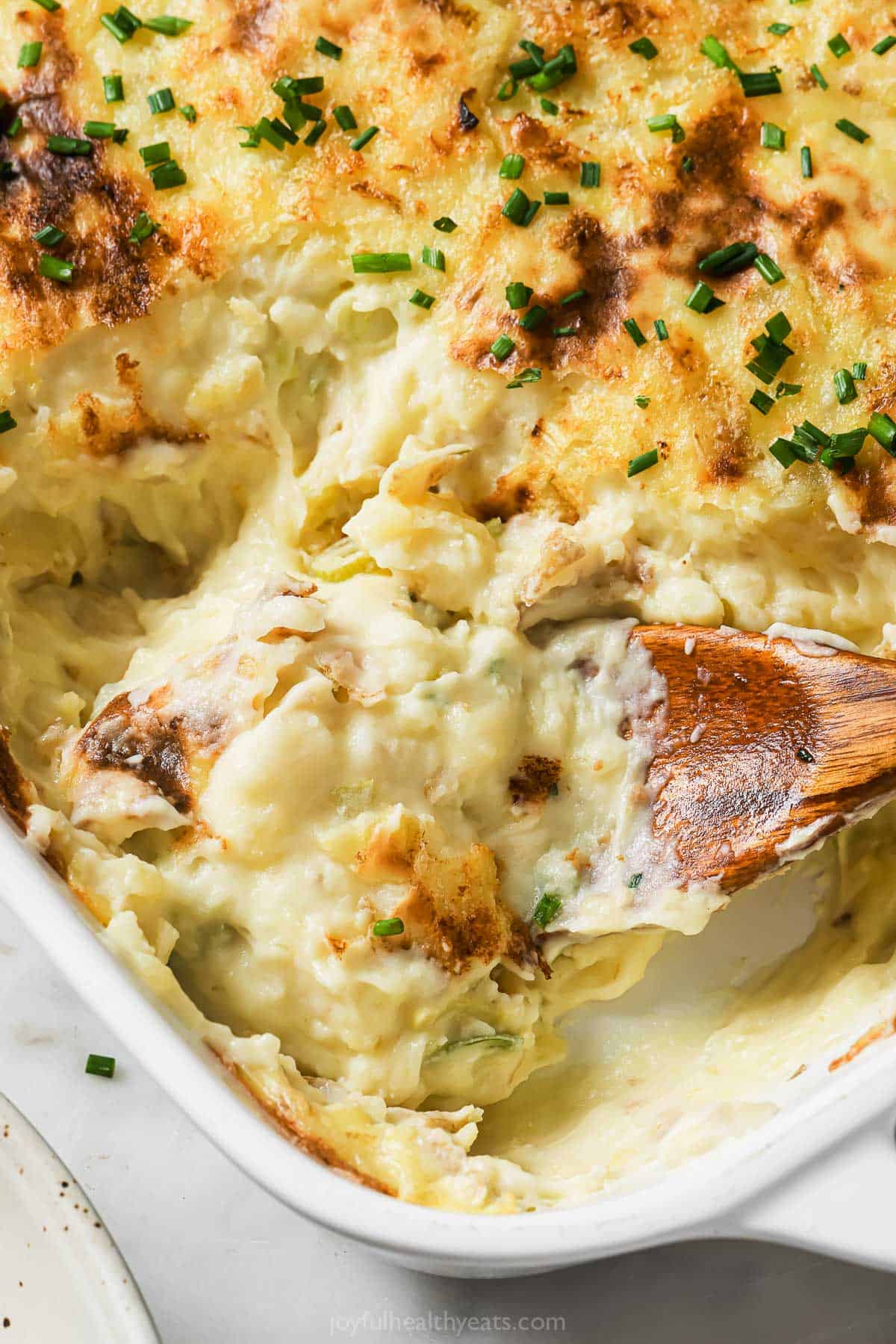 Grabbing mashed potatoes with a wooden spoon.