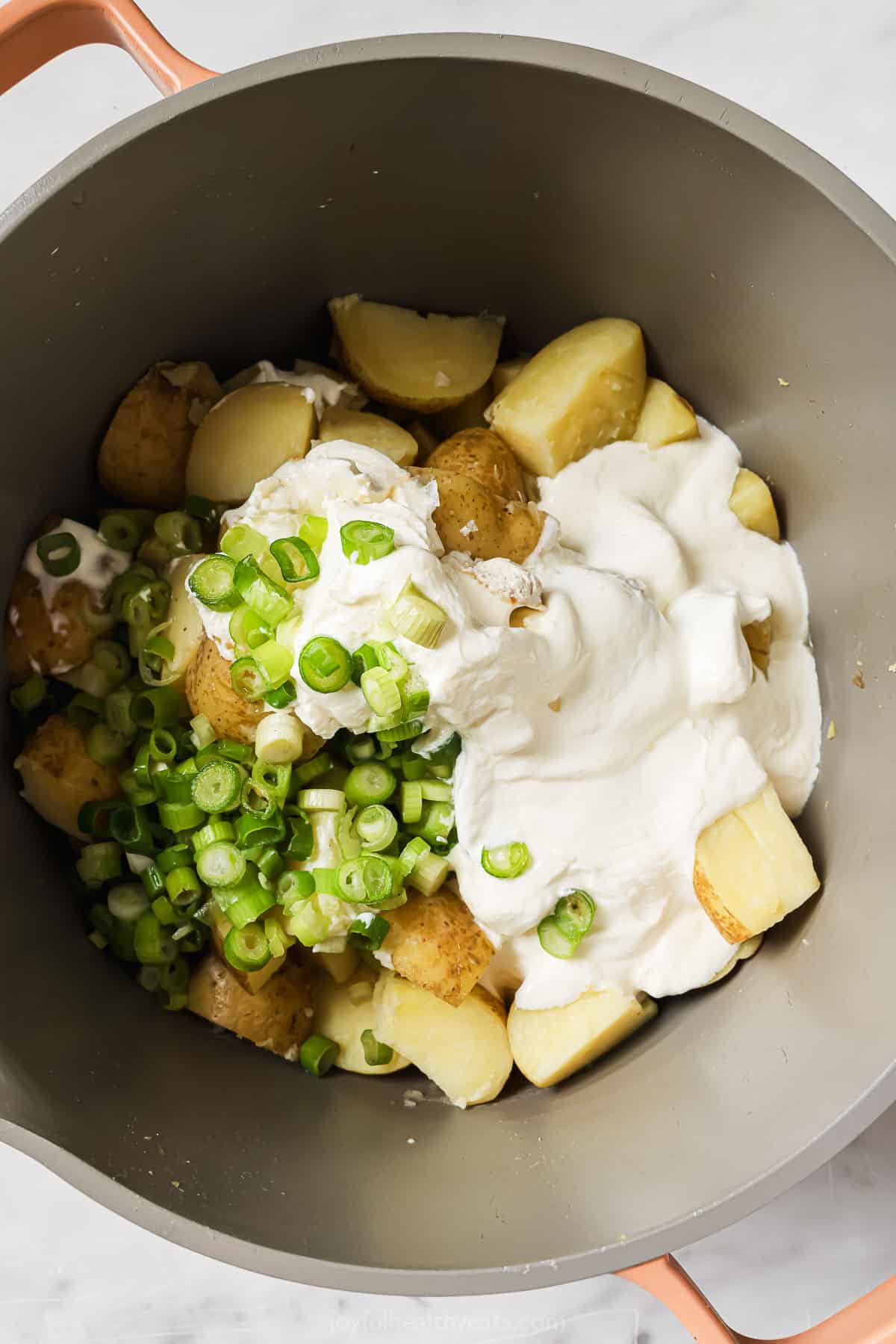 Adding the boiled potatoes and the remaining ingredients to the pot. 