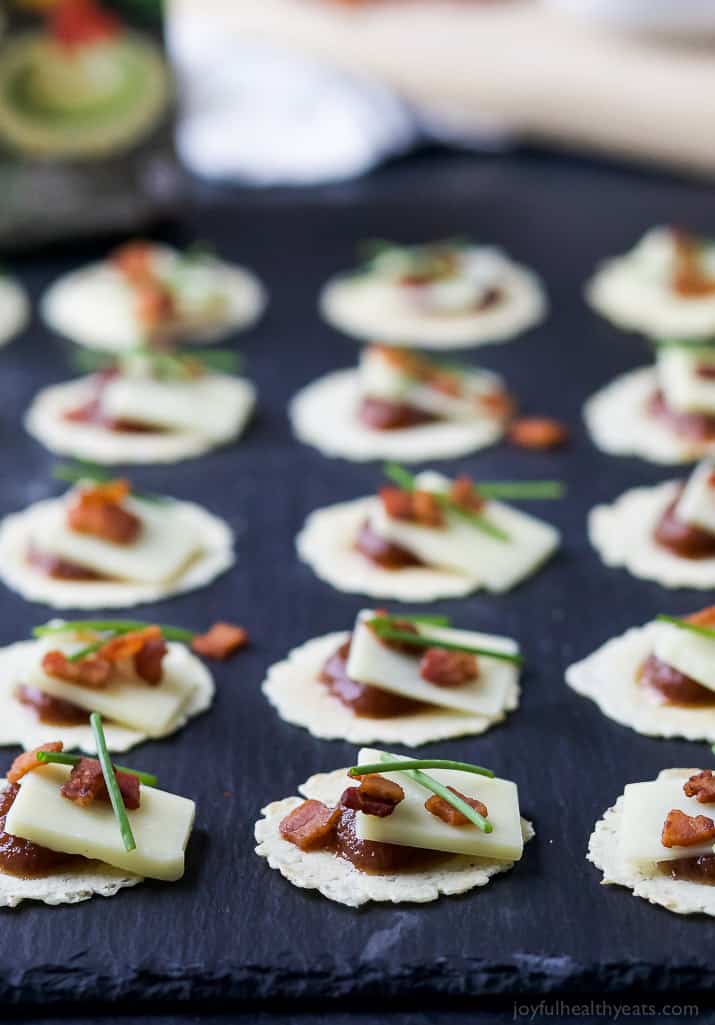 A Close-Up Shot of Apple Cheddar Bacon Bites Lined Up on a Black Surface