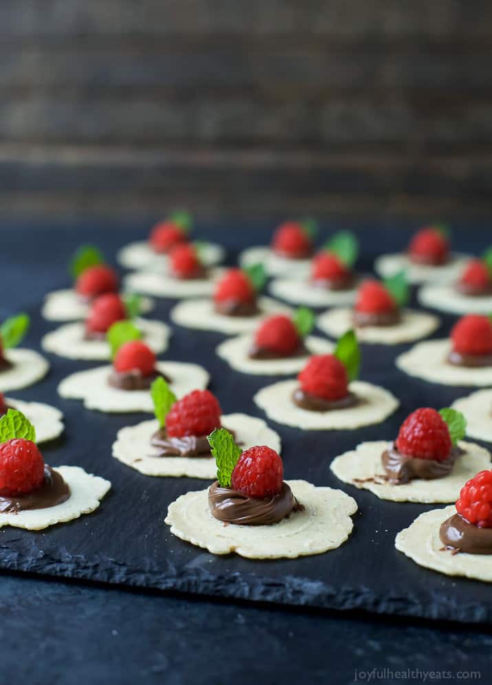 Twenty-Two Sweet Raspberry and Nutella Appetizer Bites Lined Up on a Black Serving Platter