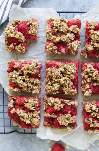 Nine Fresh Almond Oat Raspberry Bars Sitting on a Wire Cooling Rack