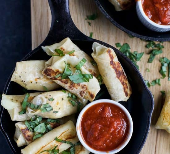 Skinny Baked Mozzarella Sticks wrapped in wonton wrappers, filled with gooey cheese, baked until golden brown and served with marinara sauce. These mozzarella sticks are the perfect party appetizer, sure to please a crowd!