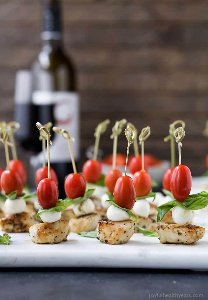 Bites of chicken, mozzarella and tomatoes with some basil.