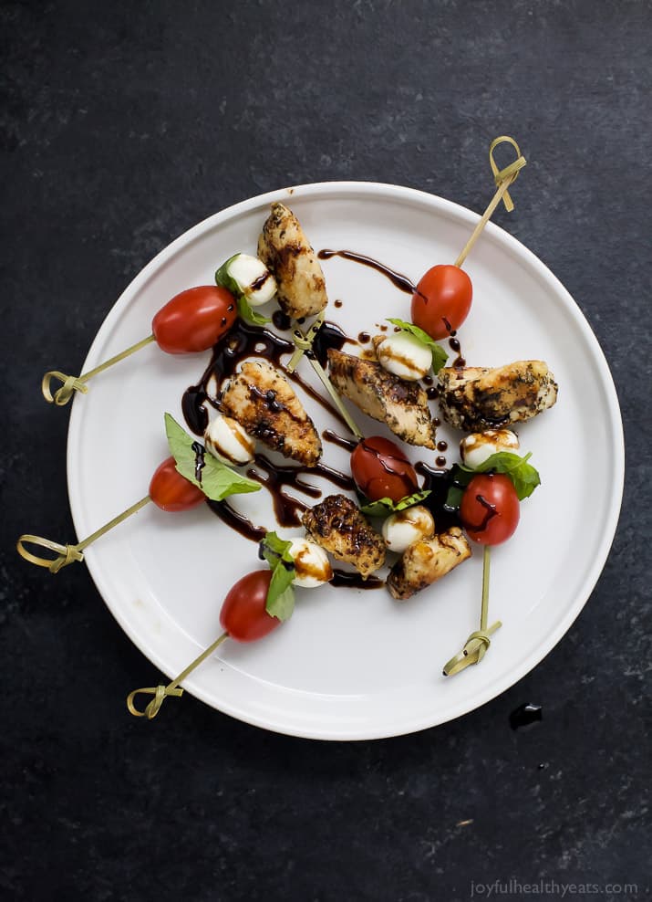 Top view of Caprese Chicken Skewers drizzled with a homemade Balsamic Glaze on a plate