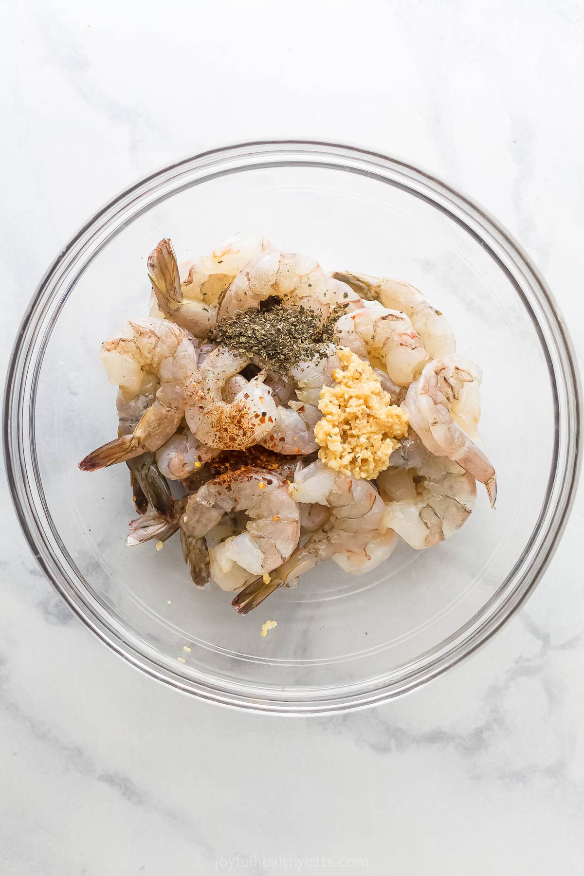 Mixing the shrimp with the garlic, basil, red pepper flakes, etc. 