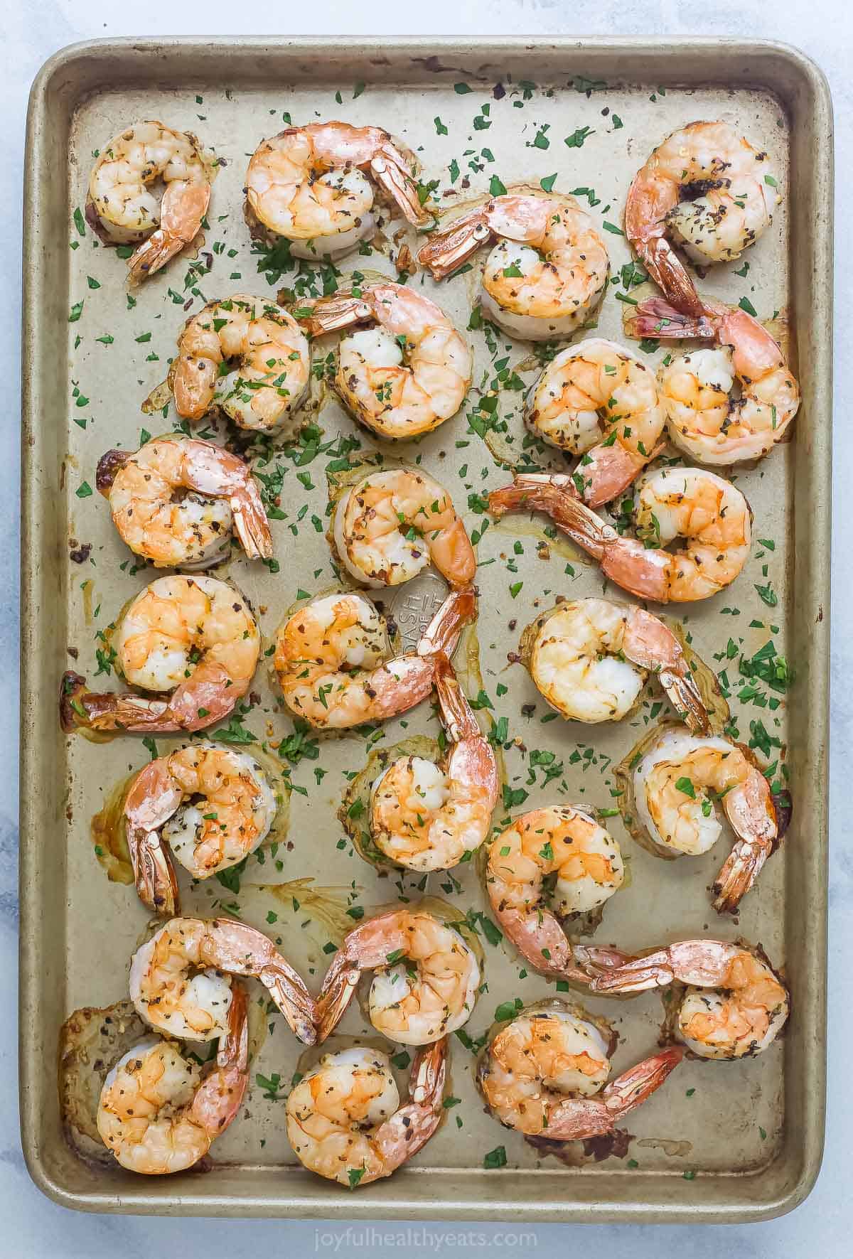 Spreading the shrimp on a baking sheet. 