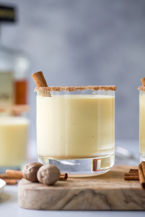 Spiked eggnog with a nutmeg rim and a cinnamon stick stirrer.