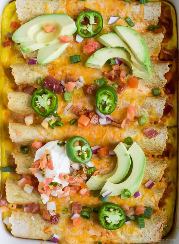 Easy Cheesy Overnight Breakfast Enchiladas filled with bacon, ham, veggies and an egg mixture. Make it the night before and bake in the morning! A delicious savory breakfast recipe perfect for brunch or the holidays!