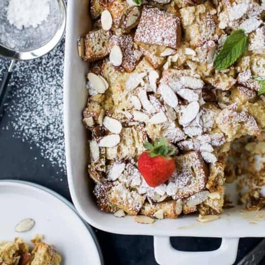 A Christmas casserole topped with powdered sugar and fresh strawberries