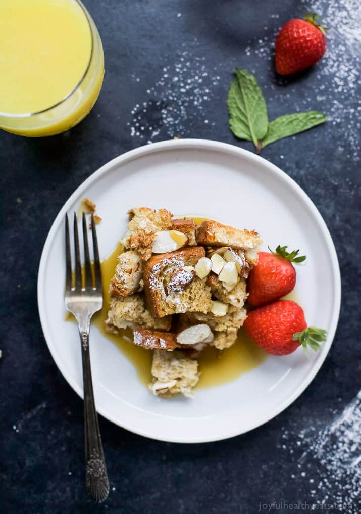 A helping of chai eggnog French toast bake on a plate with a fork and maple syrup