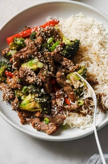 Beef and broccoli stir fry with a side of rice noodles.