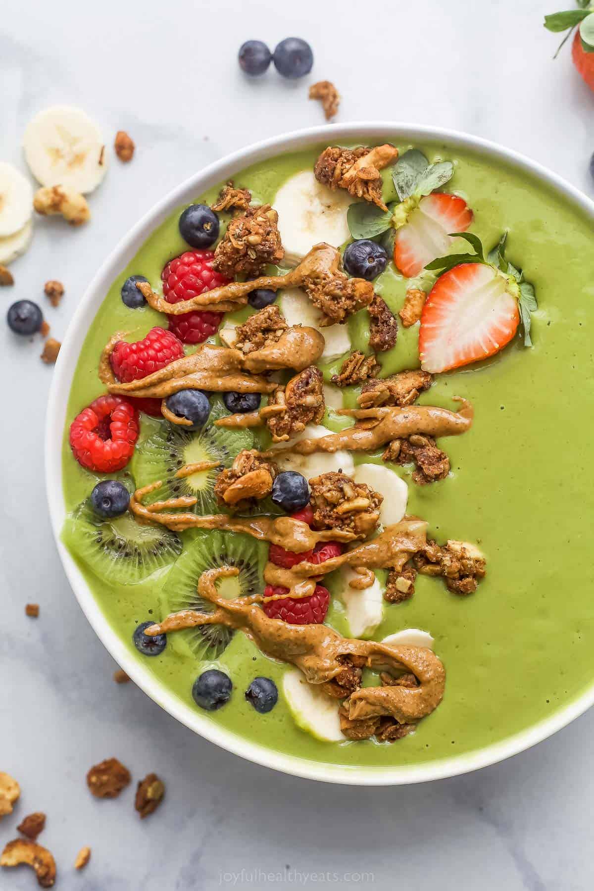 green smoothie bowl with fresh fruit and peanut butter drizzle