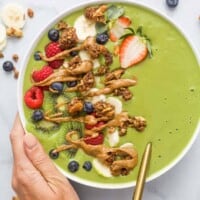 green smoothie bowl with fresh fruit and peanut butter drizzle