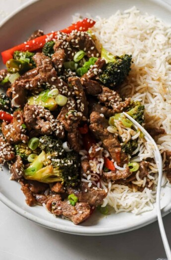 Beef and broccoli stir fry with a side of rice noodles.