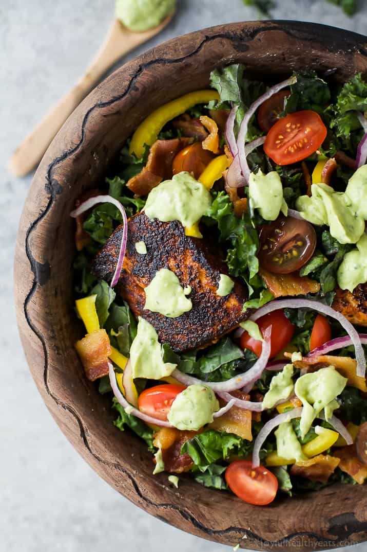 BLT Salmon Salad topped with creamy Avocado Dressing in a wooden bowl