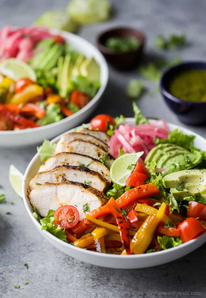 Chicken Fajita Salad in a bowl with fresh veggies, chipotle chicken, sliced avocado and zesty Chimichurri Dressing