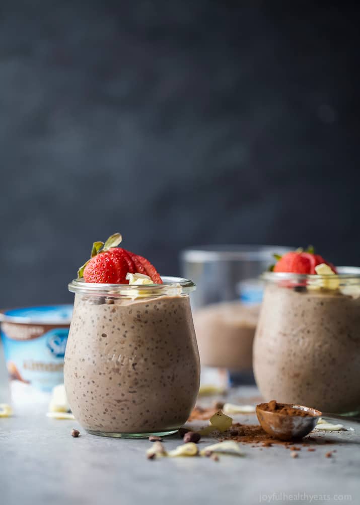 Coconut Dark Chocolate Chia Pudding in jars topped with fresh strawberries