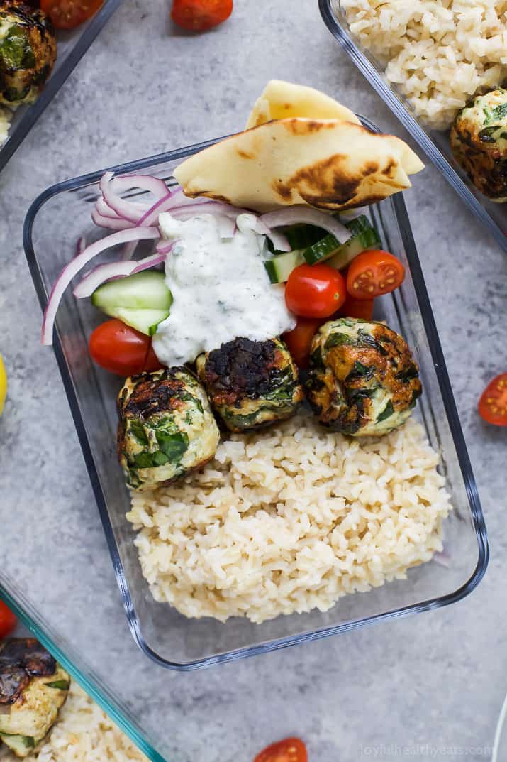 Top view of Gyro Turkey Meatball Grain Bowls with rice, vegetables, pita bread and a creamy Tzatziki sauce