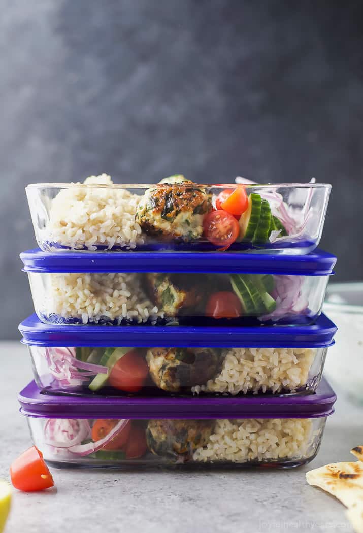 A stack of meal prep containers of Gyro Turkey Meatball Grain Bowls with rice and vegetables