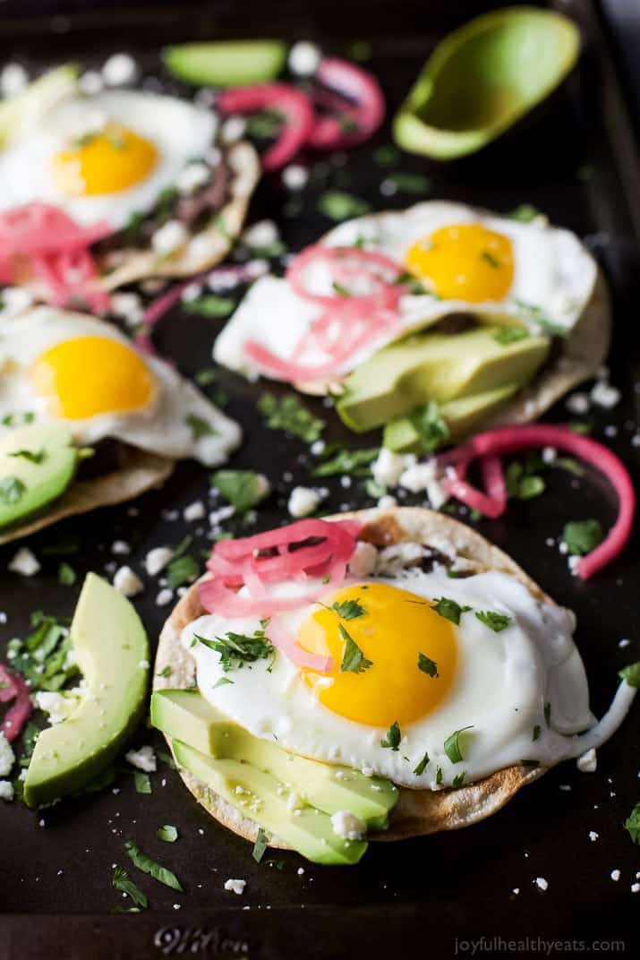 Healthy Huevos Rancheros Breakfast Tostadas topped with creamy avocado and pickled onions. These breakfast tostadas are a delicious breakfast option that are high in protein and fiber with only 292 calories a serving!