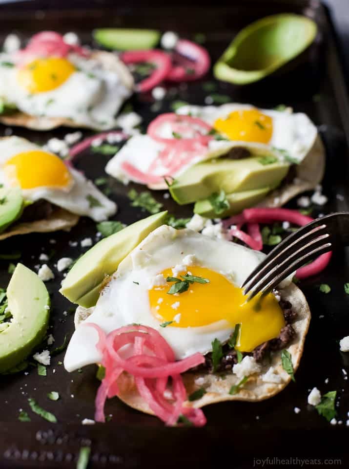 Healthy Huevos Rancheros Breakfast Tostadas topped with creamy avocado and pickled onions. These breakfast tostadas are a delicious breakfast option that are high in protein and fiber with only 292 calories a serving!