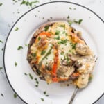 stuffed mushroom on a plate with peppers and melted cheese